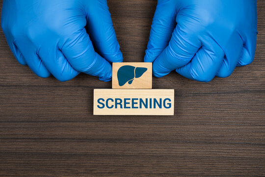 A doctor's hand arranges wooden cubes with icons representing the liver and gallbladder. Concept of liver screening, diagnosis of benign pathology, and preventive monitoring of metabolic health.