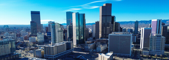 Glass high-rises pierce azure firmament above intersection connecting Park Avenue Welton Street. Sharp morning brilliance accentuates geometric forms, anchoring metropolitan heart of Denver, CO © trongnguyen