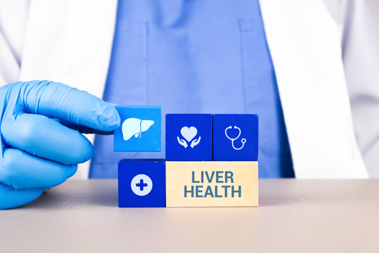 Liver diagnostic concept, medical information on early detection and prevention of liver cancer. Liver health. A hepatologist's hand arranges wooden cubes with the liver and gallbladder icons.