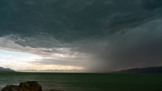 Time-lapse of severe thunderstorm rolling over Utah Lake as lightning bolts flash in the sky.
