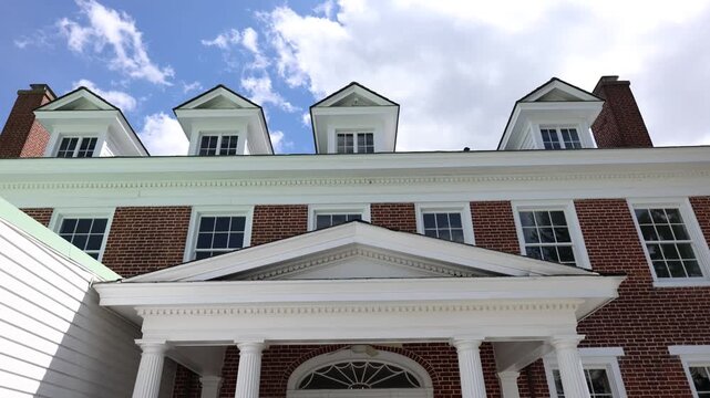 Large brick house with white columns and dormer windows