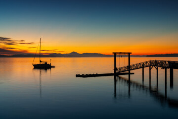 Fototapeta premium Sidney BC Fishing Pier Twilight Calm. Summer dawn twilight behind the wooden fishing pier in Sidney British Columbia, Canada. 