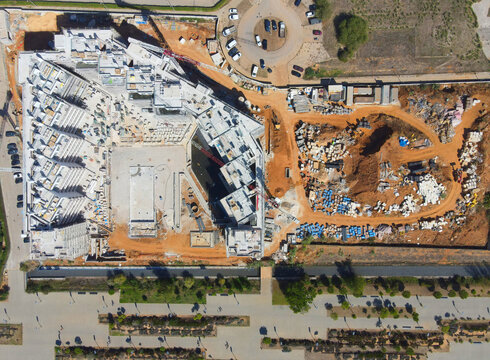 Quarteira, Portugal - 25 June 2026: Aerial view of a large construction site featuring concrete building structures, exposed earth, and construction materials in the town of Quarteira.