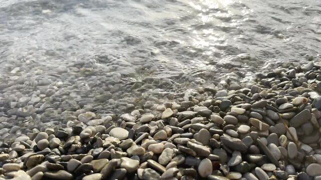 Sea crab running to the water, getting washed back by a wave, and escaping under the sea. Little crab fighting the sea wave on a stony shore and successfully escaping into the ocean, survival concept