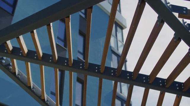 Modern pergola with wooden slats against blue sky