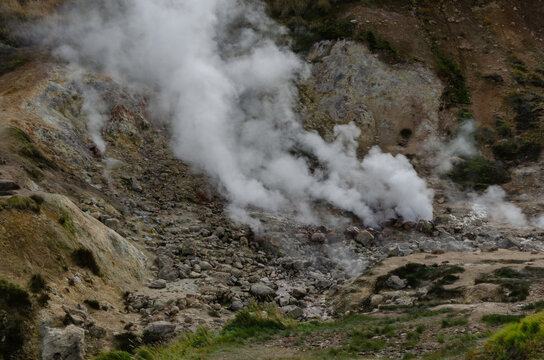 Dense steam rises from active fumaroles and hot spring vents at Dachnye Hot Springs in the volcanic landscape of Kamchatka, Russia