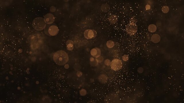Glitzy luxury background with glittering shiny gold particles and shimmering bokeh light. Elegant golden background ideal for special occasions, events, award ceremonies and talent shows. 