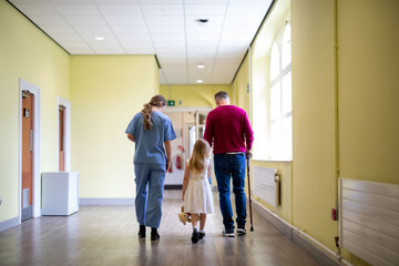 Fototapeta premium Family walking hospital corridor together.