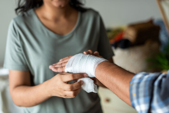 Caring hands bandaging injured hand