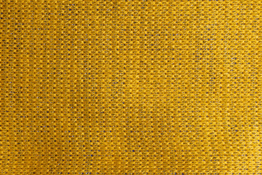 Yellow knitted wool fabric texture closeup detailed interlocking yarn loops