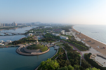 Obraz premium Yantai coastal square with harbor cityscape featuring green parks sandy beach and modern architecture