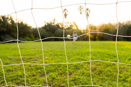 out of focus soccer ball and net