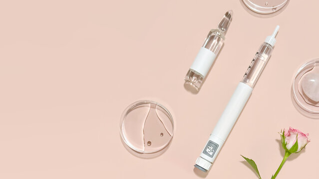 Beauty Injection Concept with Syringe Pen, Glass Vial, and Cosmetic Tools on Soft Pink Background with Copy Space, for Aesthetic Medicine, Anti Aging Treatments, Skin Rejuvenation and Wellness Clinics