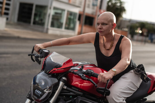 Bald woman driving naked motorcycle