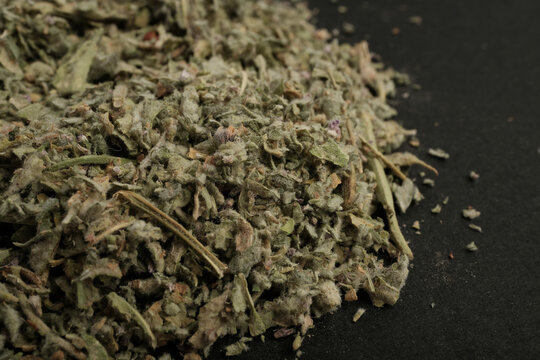 Heap of Dried Pennyroyal Herb Crushed Leaves on Black