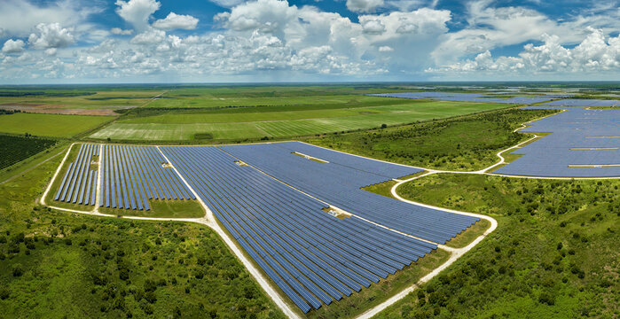 Aerial view of large sustainable electrical power plant with rows of solar photovoltaic panels for producing clean electric energy. Concept of renewable electricity with zero emission