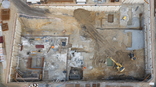 Portugal - 24 June 2026: Aerial view of building foundations construction site with excavation, heavy machinery, and construction materials.