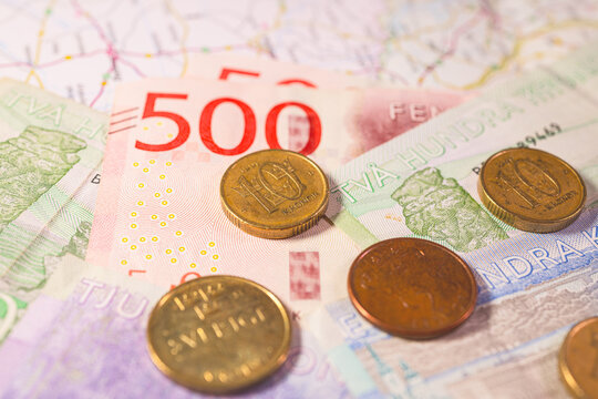Swedish krona banknotes and coins arranged as colorful financial background representing Scandinavian economy.