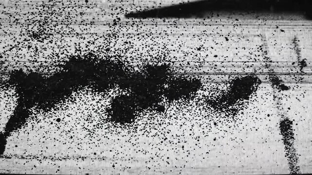 Abstract black splatter pattern on textured surface with high contrast and dynamic composition
