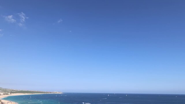 Beautiful panoramic wide angle view of the turquoise ocean bay with boats and luxury tropical beach resorts in Cabo San Lucas Mexico near Los Arcos
