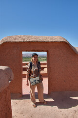 Fototapeta premium A senior tourist enjoys her trip visiting the terraces of the historic Taourirt Kasbah in Morocco