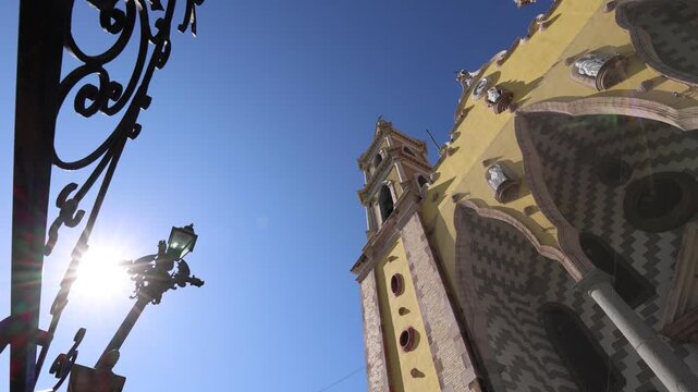 Beautiful low angle view of the ornate yellow facade and twin steeples of the Cathedral Basilica of the Immaculate Conception in the historic center of Mazatlan Mexico