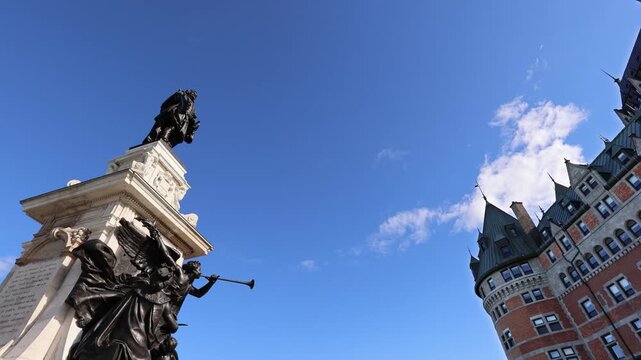 Beautiful low angle view of the historic Samuel de Champlain statue and the iconic turret of Fairmont Le Chateau Frontenac hotel