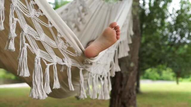 Close-up of Bare Foot Resting in Fringe Hammock Outdoors