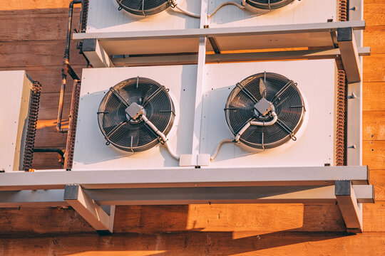 Outdoor chiller units mounted on a wooden wall, providing ventilation and air conditioning for a commercial building