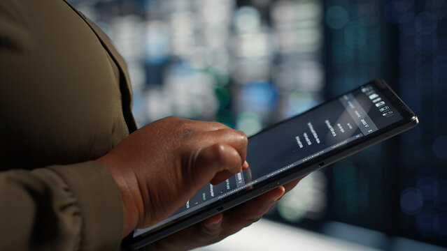 Programmer uses tablet in a data center to upgrade server hardware and improve workload capacity.