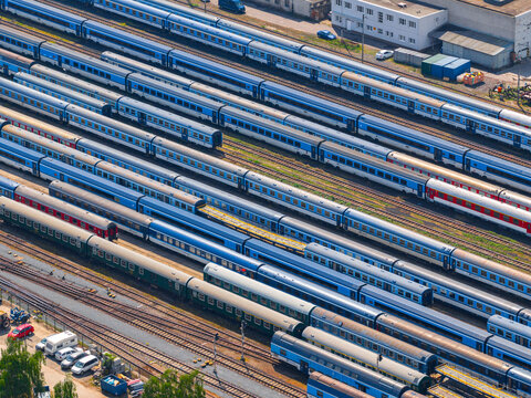 Aerial view of an industrial area with multiple passenger trains parked on parallel tracks in Prague, Prague, Czechia.