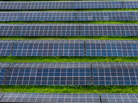 Aerial view of rows of solar panels installed in a green field in Suntazi, Ogre Municipality, Latvia.