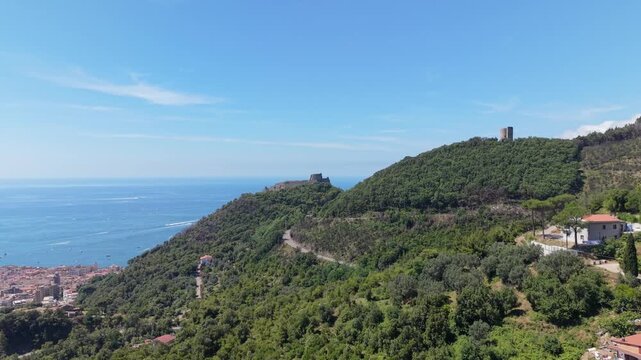 Aerial view of Castello di Arechi above Salerno, Italy, with the historic hilltop fortress, forested slopes, winding road, coastal town and Gulf of Salerno