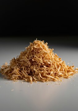 Fluffy, light brown pile of fresh pine wood shavings gathered on a clean surface, emphasizing texture and natural material for crafts, fresh, background, surface