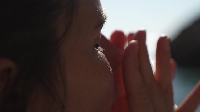 Sunscreen skincare beach woman applying sun protection cream on her face outdoors near the ocean during a sunny summer vacation day