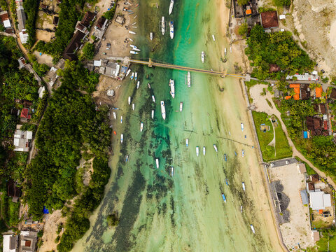 Aerial perspective of small boats moored in a shallow turquoise water channel