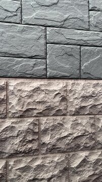 Close-up cottage facade panel natural stone, textured grey stacked blocks over rough beige basecourse, precise mortar joints