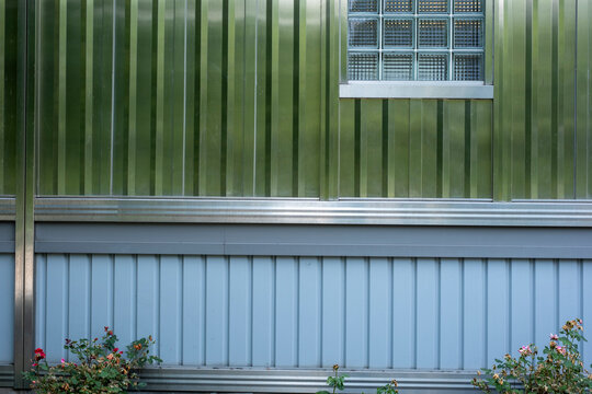 Corrugated metal siding and glass block window with roses