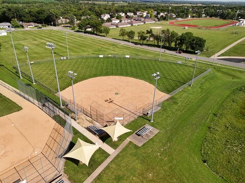 High aerial view of empty little league baseball diamond field in public community park on sunny summer day showcasing youth sports facilities