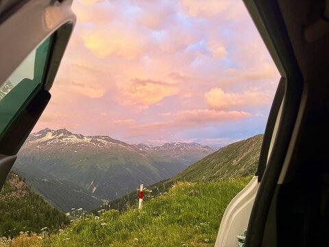 Pink sunset over snow-streaked Bernese Alps peaks framed by the open