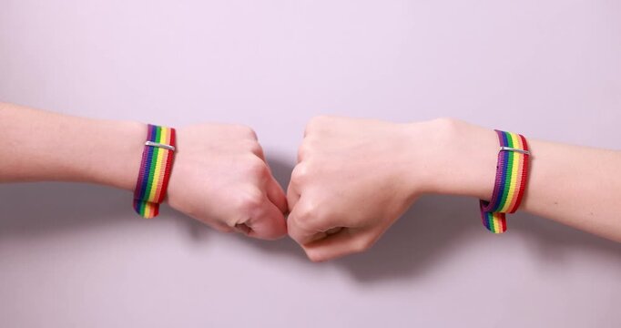 LGBT concept. Women bumping fists on light background, closeup