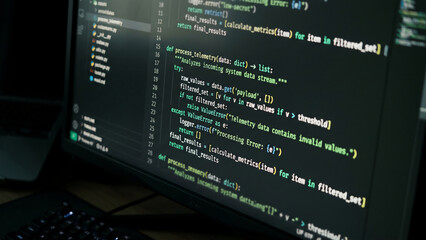 Fototapeta premium Computer screen displaying lines of code in a dark environment.