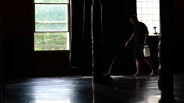 Man cleaning the gym mat space, hygiene moping cleaning, martial arts theme