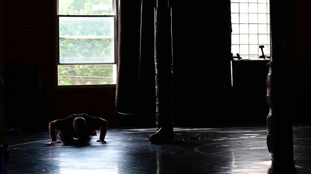 Boxing martial arts gym in silhouette pushups strength training, practicing martial arts, perfect copy space background video, kickboxing fight sport wellness 