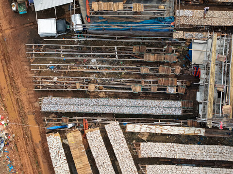 Aerial view of fish drying on wooden racks at the Kali Baru fishing port, with rows of salted fish laid out under the sun in Cilincing, Jakarta, Indonesia.
