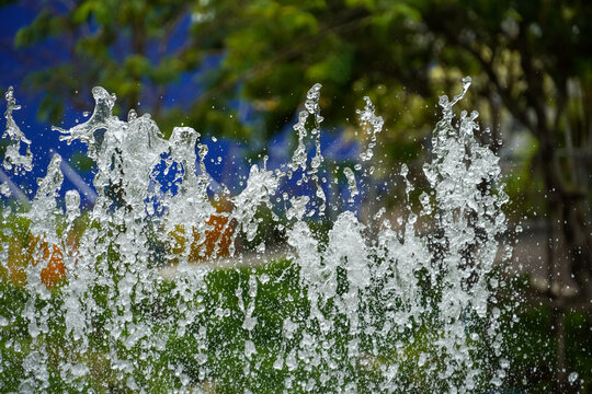 Dynamic water splashes frozen in motion against a blurred green and blue background