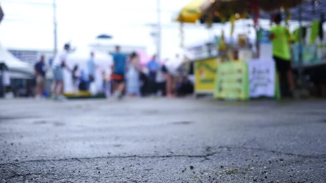 Crime Doc Filler Shot - Blurry People in Fair or Festival near Vendor Stands.
