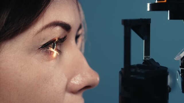 Female patient undergoing eye examination with slit lamp, focusing on detailed evaluation of the eye, medical equipment visible in clinical setting