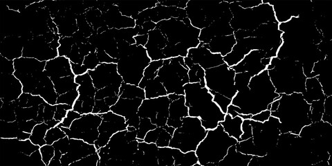 Fototapeta premium Abstract dark background featuring a dramatic high contrast texture of white cracked fissures and dry lines on a solid black surface.
