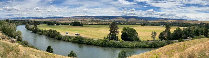 Obraz premium The Kittitas Valley in a panoramic view near Ellensburg Washington on a lovely summer day with the Yakima river in the left foreground and a great cloudy sky_20260627_9318.